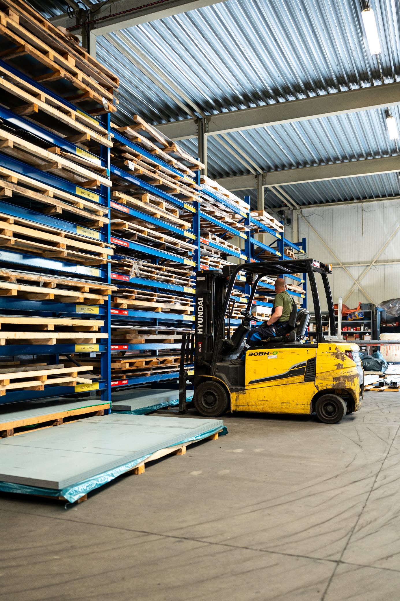 Heftruck bij een groot plaatmateriaal-opslagrek — productiecapaciteit en continuïteit binnen Acero Group